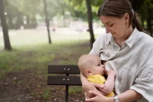 Madre amamantando a su bebé en un parque durante una etapa de lactancia y destete respetuoso